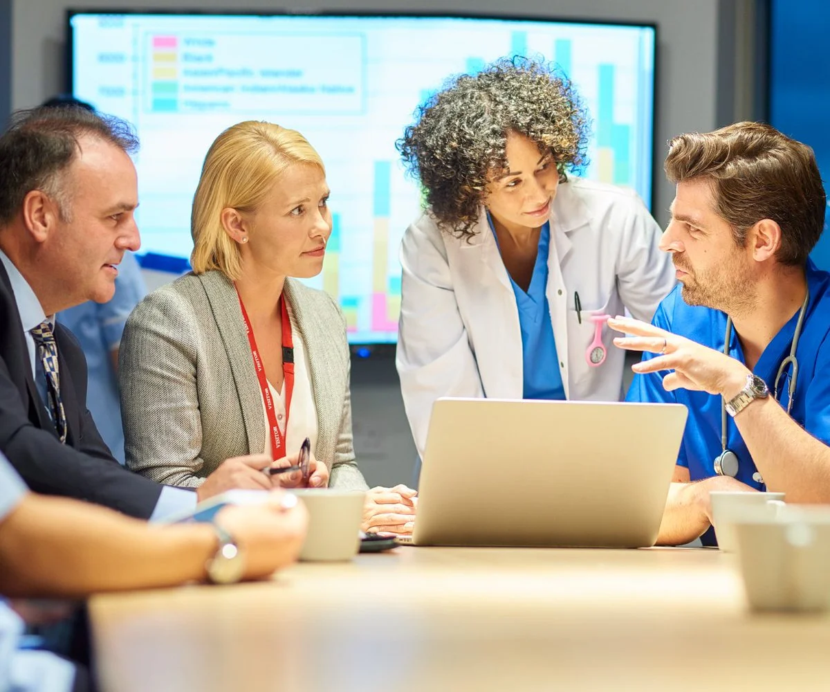 Medical professionals discussing digital data. | Global Med-Eng Consulting